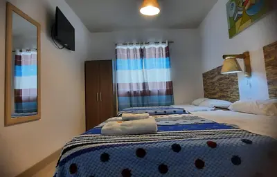 a bedroom with two beds and a mirror at Hostal Brisa Marina in Paracas