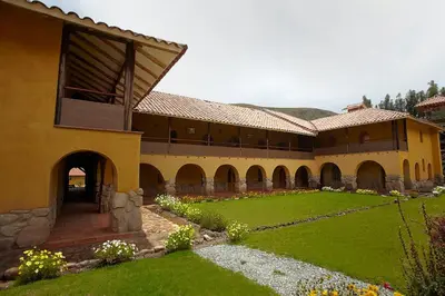 a large building with a green yard in front of it at Willka Rumi in Urubamba