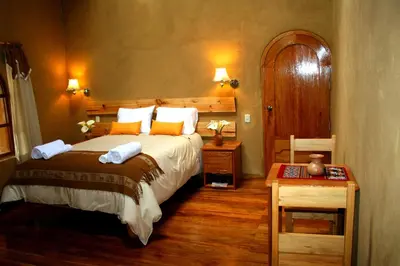 a bedroom with a large bed and a wooden floor at Willka Rumi in Urubamba