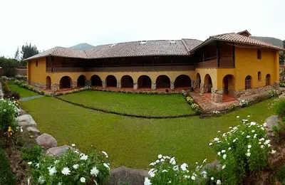 a large building with a green lawn in front of it at Willka Rumi in Urubamba
