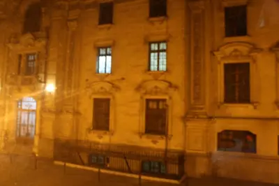 a large building at night with a street at Main Square in Lima