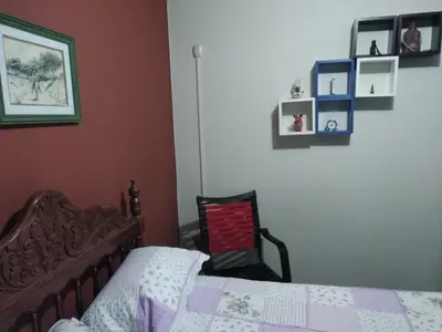 a bedroom with a bed and some pictures on the wall at Main Square in Lima