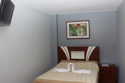 a bedroom with a bed with two swans on it at Hostal Las Fresas Lima Airport in Lima