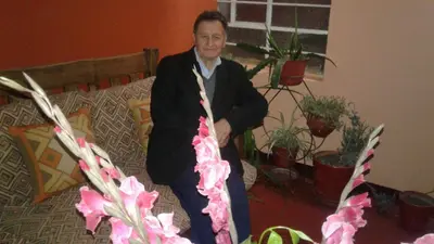 a man sitting on the floor next to some plants at Qoricancha B&B Cusco in Cusco