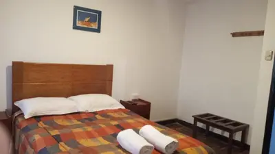 a bedroom with a bed with two pillows on it at Qoricancha B&B Cusco in Cusco
