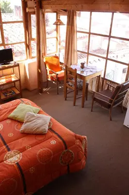 a bedroom with a bed and a table and chairs at Casa De Mama Cusco - The Treehouse in Cusco