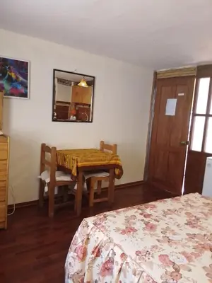 a bedroom with a table and a bed and a mirror at Casa De Mama Cusco - The Treehouse in Cusco