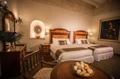 a hotel room with two beds and a table at Aranwa Cusco Boutique Hotel in Cusco