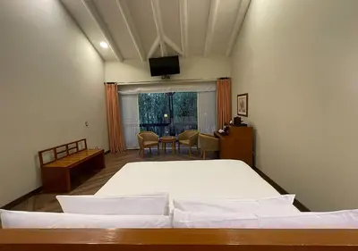 a bedroom with a bed and a table and a television at Aranwa Sacred Valley Hotel & Wellness in Urubamba