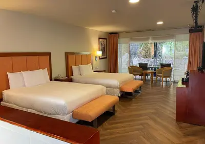 a hotel room with two beds and a table and chairs at Aranwa Sacred Valley Hotel & Wellness in Urubamba