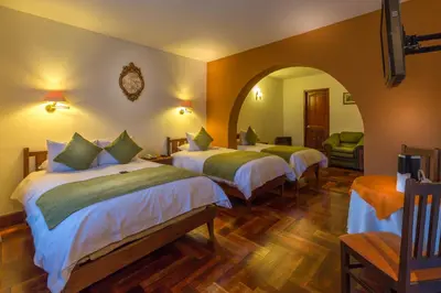 a hotel room with three beds in a room at Katari Plaza Cusco El Virrey in Cusco