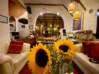 a living room with sunflowers on a table at Hostal Madre Tierra in Cusco