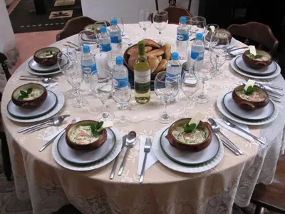 a table with plates of food and wine glasses at Hostal Madre Tierra in Cusco