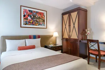 a hotel room with a bed and a chair at LP Los Portales Hotel Cusco in Cusco