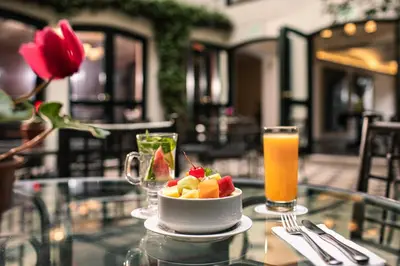 a bowl of fruit on a table with a drink at LP Los Portales Hotel Cusco in Cusco