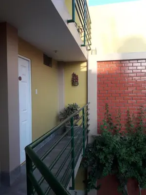 a stairway with a white door and a brick wall at Hostal Tambo Colorado in Pisco