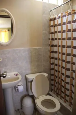 a bathroom with a toilet and a sink and a mirror at Hostal Tambo Colorado in Pisco