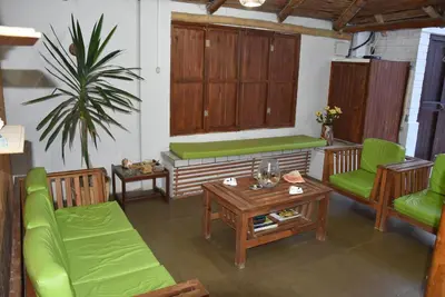 a living room with green chairs and a table at La Casa Maruja in Lima