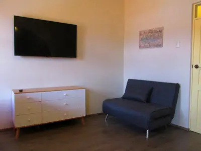 a living room with a chair and a tv on the wall at Best View apartment downtown Cusco in Cusco