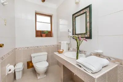 a white bathroom with a toilet and a sink at SAUCE Hotel Boutique in Ollantaytambo