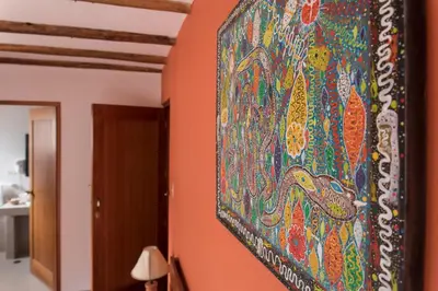 a large painting hanging on a wall in a room at SAUCE Hotel Boutique in Ollantaytambo