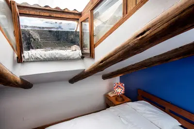 a small bedroom with a bed and a window at SAUCE Hotel Boutique in Ollantaytambo