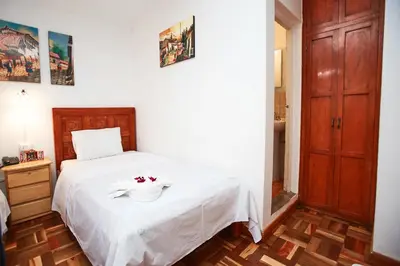 a bedroom with a white bed with a bowl on it at Hostal Danna Inn in Cusco