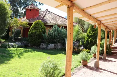 a wooden pergola in front of a house at Hotel Villa Urubamba in Urubamba