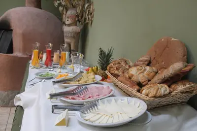 a table with bread and a basket of food on it at Hotel Villa Urubamba in Urubamba