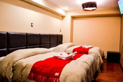a bedroom with two dolls laying on a bed at Hotel Royal Qosqo in Cusco