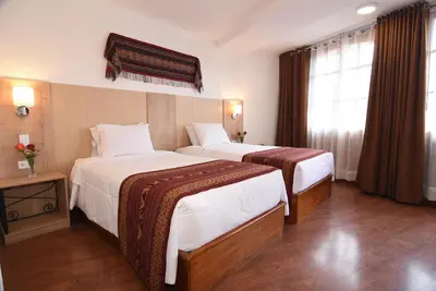a hotel room with two beds and a window at Hotel Prisma Cusco in Cusco