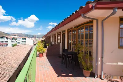 a balcony of a building with a table and chairs at Hotel Prisma Cusco in Cusco