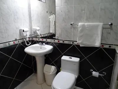 a bathroom with a white toilet and a sink at Ccapac Inka Ollanta Casa Museo in Ollantaytambo