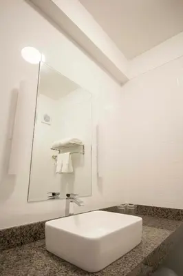 a white bathroom with a sink and a mirror at Tierra Viva Miraflores Mendiburu in Lima