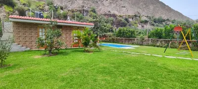 a house with a yard with a playground at Casa de Campo Chinkay - Lunahuana in Lunahuaná
