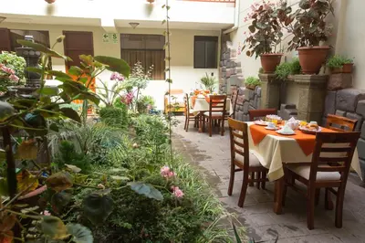 an outdoor patio with tables and chairs and plants at Antawasi Hotel in Cusco
