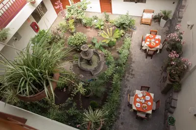 an overhead view of an indoor garden with tables and plants at Antawasi Hotel in Cusco