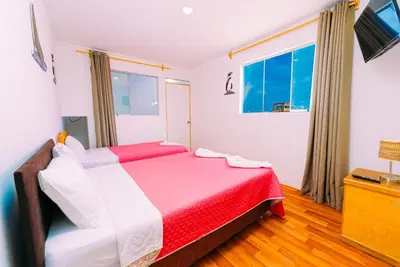 a bedroom with two beds and a window at Hospedaje Mary in Paracas