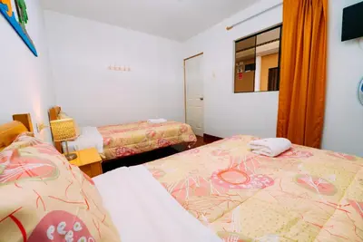 a bedroom with two beds and a mirror at Hospedaje Mary in Paracas