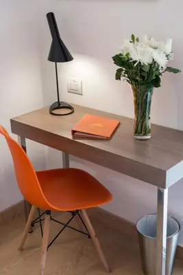 a desk with a vase of flowers and a chair at Libre Hotel, BW Signature Collection by Best Western in Lima