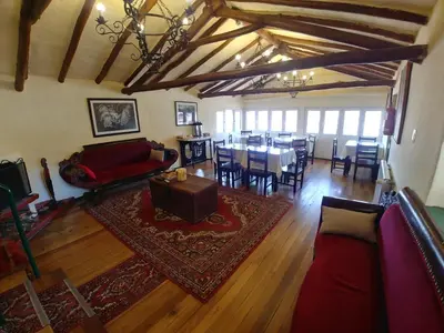 a living room with a couch and a table and chairs at Hostal Corihuasi in Cusco