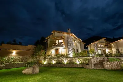 a house with lights on the lawn at night at Intiterra Apart Hotel Villas in Urubamba