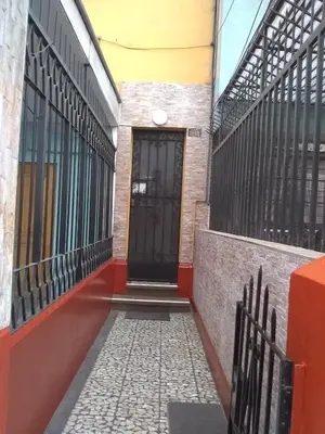 a building with a black door and a gate at Hospedaje Marita in Lima