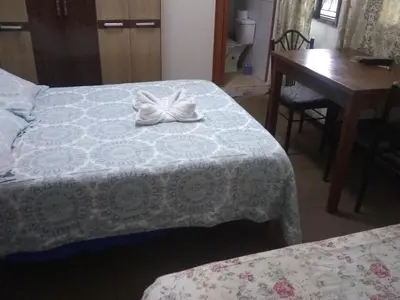 a hotel room with two beds and a desk and a table at Hospedaje Marita in Lima