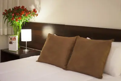 a bedroom with a bed with a vase of flowers at El Angolo in Lima