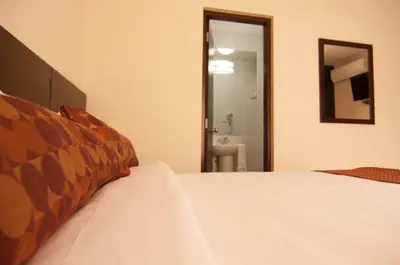a bedroom with a bed and a mirror and a bathroom at Tambo Dos de Mayo in Lima