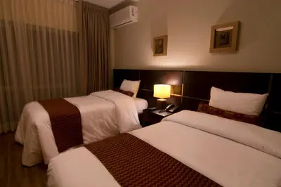 a hotel room with two beds and a lamp at Tambo Dos de Mayo in Lima