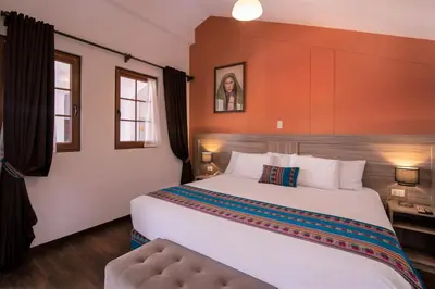 a bedroom with a large white bed in a room at Atoq San Blas Hotel in Cusco