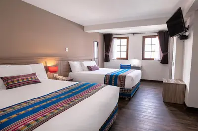 a hotel room with two beds and a flat screen tv at Atoq San Blas Hotel in Cusco