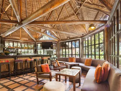 a lobby of a resort with a bar at Inkaterra Machu Picchu Pueblo Hotel in Machu Picchu
